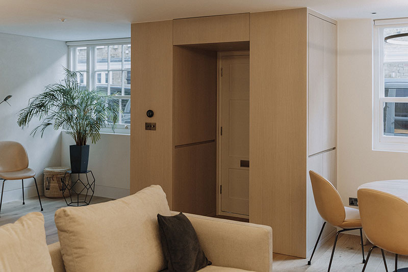 Open-plan living space with bespoke oak joinery and concealed doorway