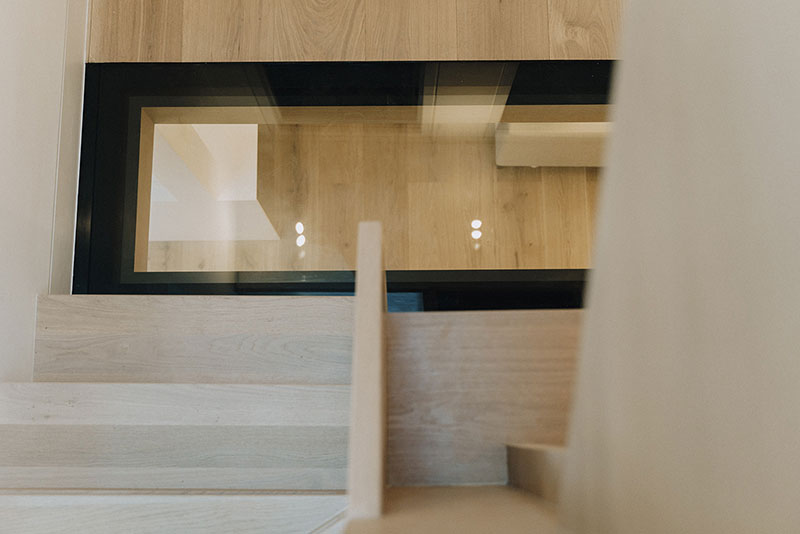 Internal glazed panel framed in oak joinery beside the staircase