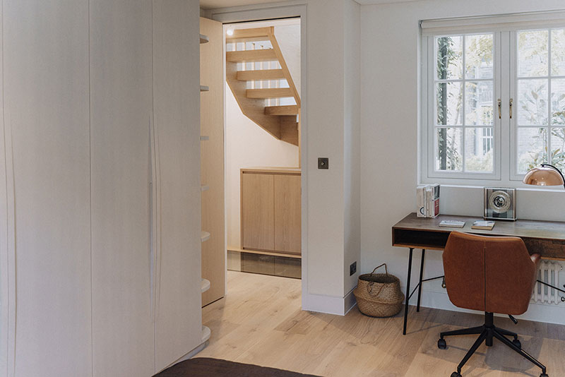 Bedroom with fitted wardrobes, study desk and view through to the staircase