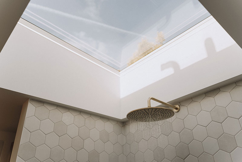 Bathroom with rooflight above a brushed brass rainfall shower and hexagonal tiling