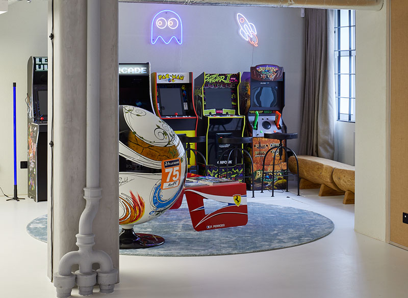 Games area with retro arcade cabinets and neon signage