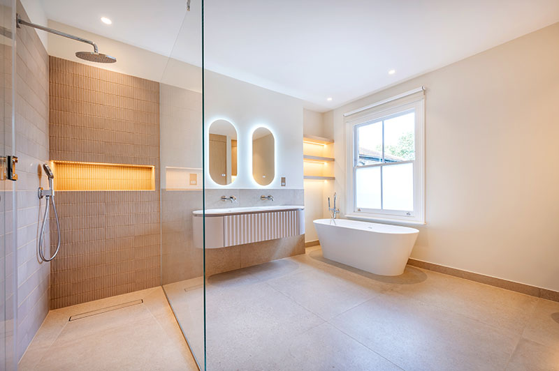 Principal bathroom with walk-in rainfall shower, freestanding bath and twin basins